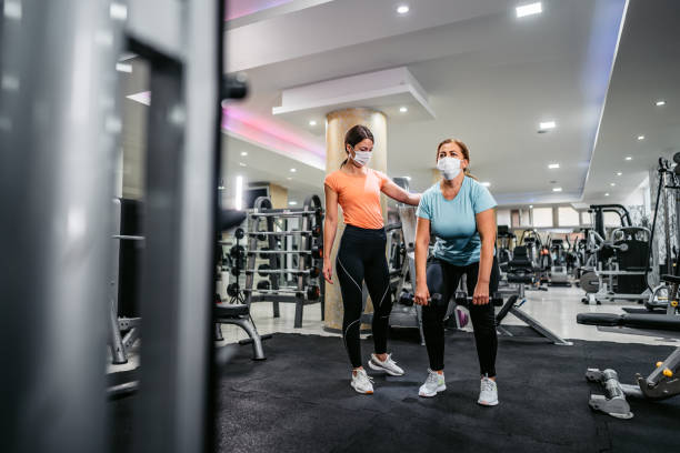 istock Senior woman doing crunches with trainers help 1305474407