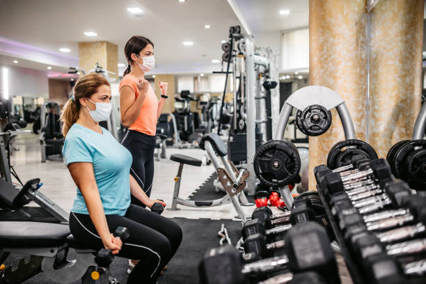 istock Senior woman doing bicep curls with trainers help 1305474506