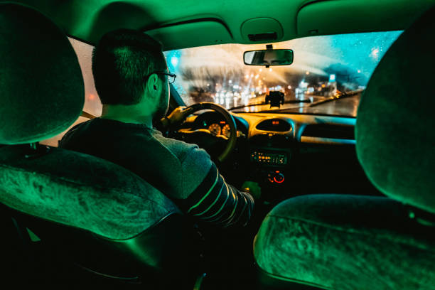 istock Man driving car on city streets 1305475955