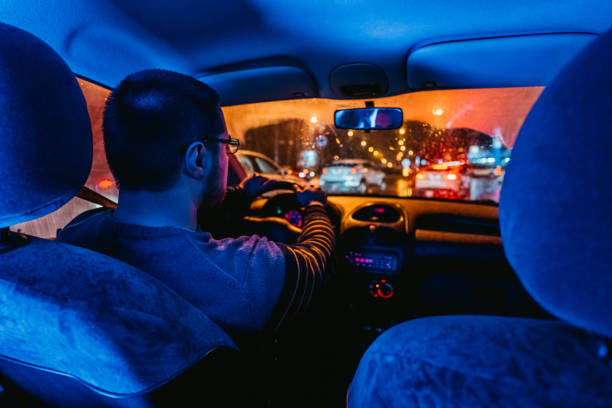istock Man driving car on city streets 1305476005