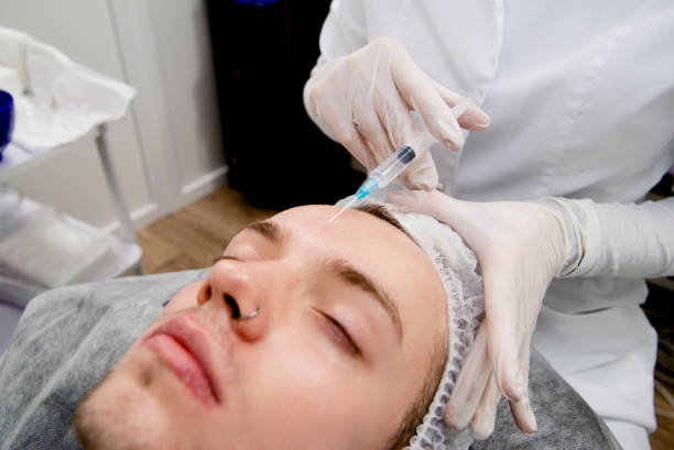 istock Dermatologist's making injections to man's face to remove scars and wrinkles and make it smooth and young 1305476961