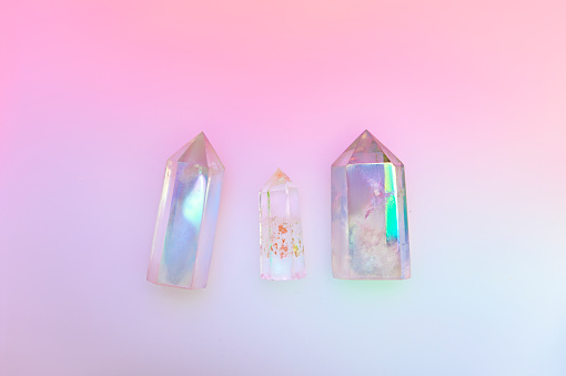 Natural clear crystal quartz electroplating rainbow on holographic background. Meditation, reiki and spiritual healing concept