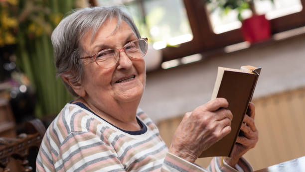 istock Old woman reading a book 1305481787