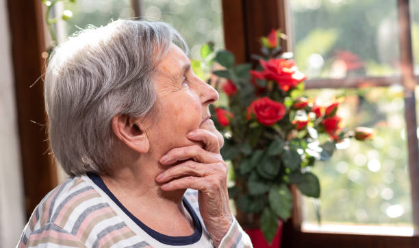 istock Elderly woman looking out the window 1305481998