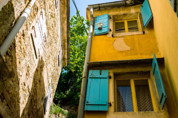 Opened teal window blinds on yellow house in Slovenia, traditional architecture in the fishermen town of Piran