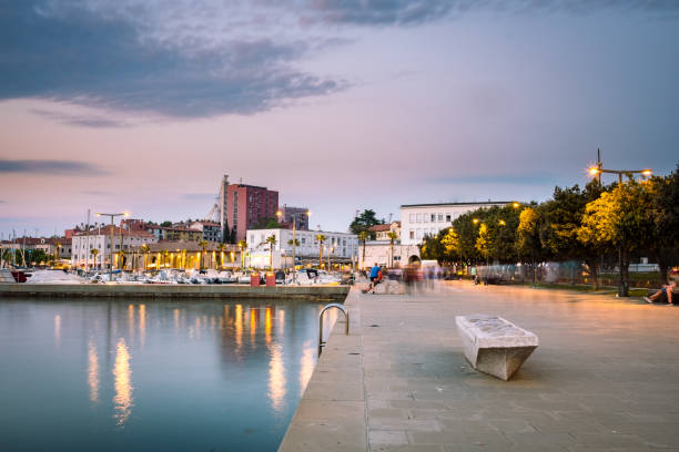 A calm evening promenade by the sea in the harbor of Koper, Slovenia after sunset A calm promenade by the sea in the harbor of Koper, Slovenia after sunset, long exposure koper slovenia stock pictures, royalty-free photos & images