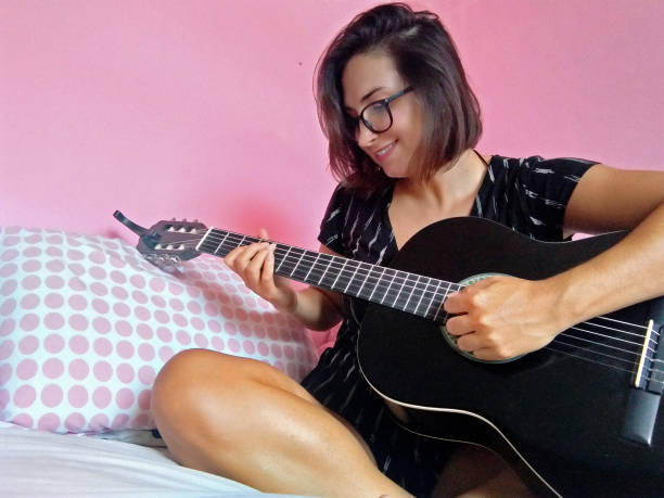 istock Girl playing a black guitar 1305490412