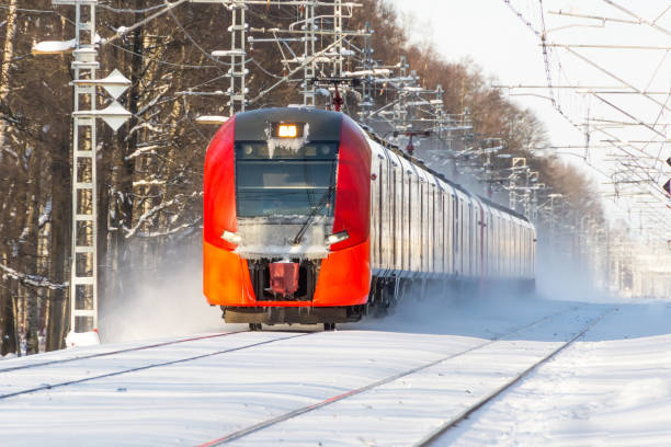 Express train passing snow covered winter landscape.