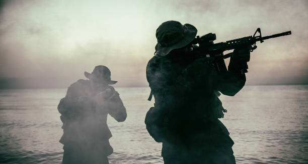 commando soldiers walking in water and aiming gun - sea battle imagens e fotografias de stock