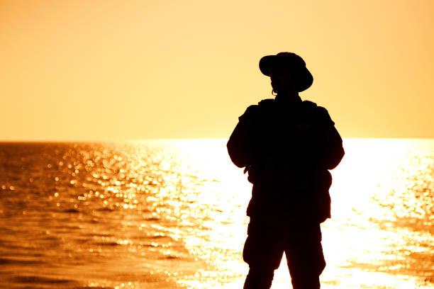 istock Coast guard soldier on sunset sea background 1305492430