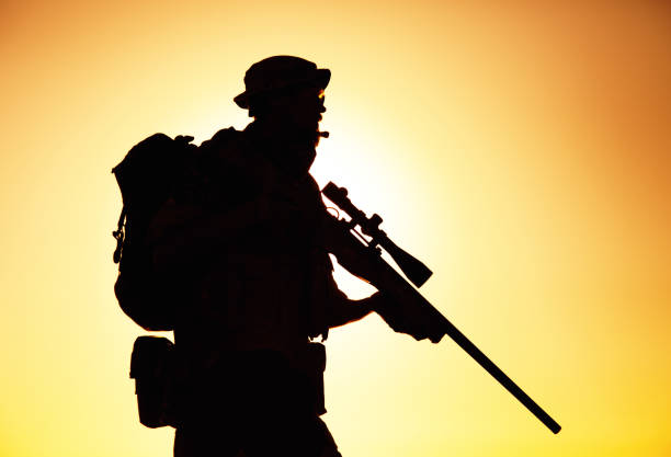 istock Silhouette of army sniper on sunset background 1305492508