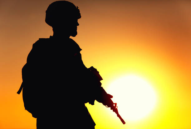 istock Silhouette of army shooter on sunset background 1305492551