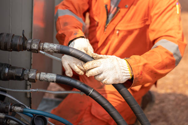 Connect and recheck the high pressure hose of power engine. Action of worker hand is connecting and checking to high-pressure hydraulic hose line of power pack engine. Industrial working action photo, Close-up and selective focus. hydraulic hose stock pictures, royalty-free photos & images