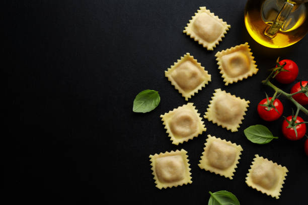istock Tasty classic italian ravioli with basil on dark background. 1305497600