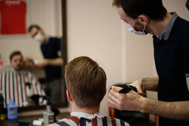 istock Barber using scissors and comb stock photo 1305498272