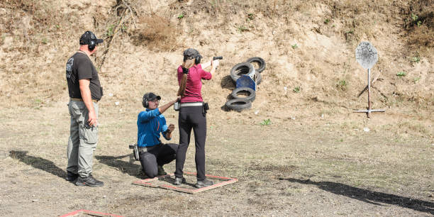 istock Young girl with coach on tactical gun training classes 1305500597