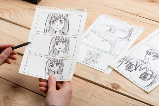 Photo of Artist drawing an anime comic book in a studio.