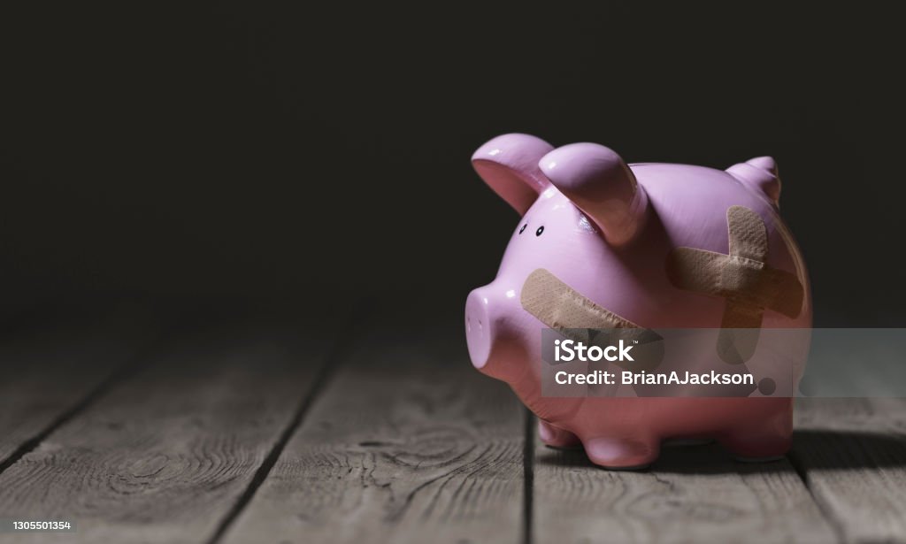 Broken piggy bank with band aid bandage or plaster finance background Broken piggy bank with band aid bandage or plaster finance background concept for economic recession or bankruptcy Poverty Stock Photo