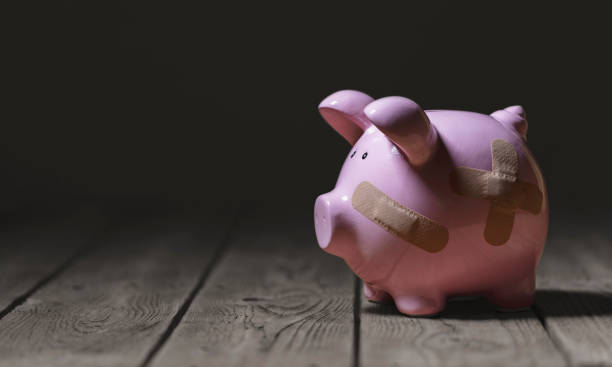 broken piggy bank with band aid bandage or plaster finance background - fome imagens e fotografias de stock