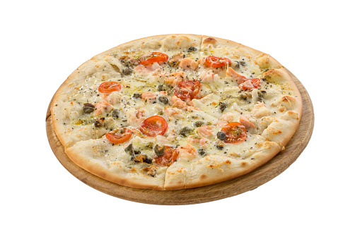 Delicious seafood pizza with salmon, capers and tomatoes on wooden board isolated on white background side view
