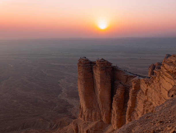 Tourists gather at Edge of the World escarpment near Riyadhduring sunset , Saudi Arabia stock photo
