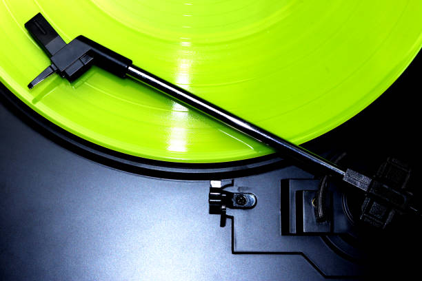 Green vinyl record spinning on a turntable - gramophone needle - directly above