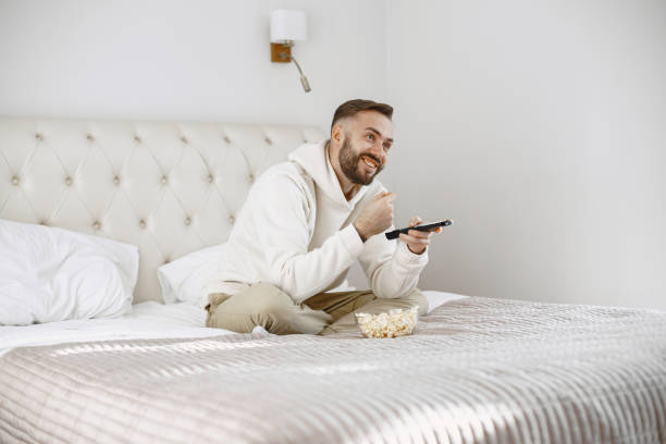 istock Single man on the couch watching TV 1305507525