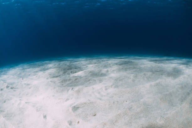 istock Blue ocean at the deep with white sand and underwater sun rays 1305507654