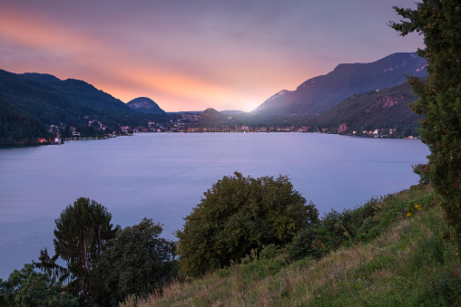 Lugano lake at sunset seen from Morcote (Vico Morcote - Canton Ticino), with the Italian town of Porto Ceresio in the background