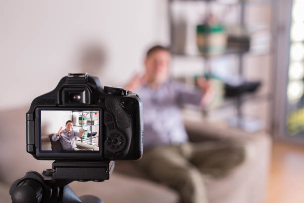 istock Vlogger recording social media video while sitting on the couch 1305508793