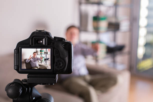 istock Vlogger recording social media video while sitting on the couch 1305509171
