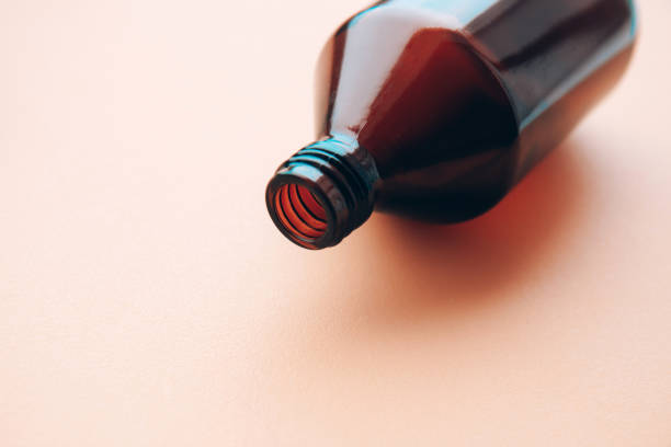 istock Empty glass bottle of cosmetic liquid on light background 1305509990