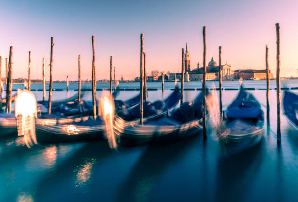 вид на венецию и гондолы с фиолетовым закатом - venice italy ancient architecture creativity стоковые фото и изображения