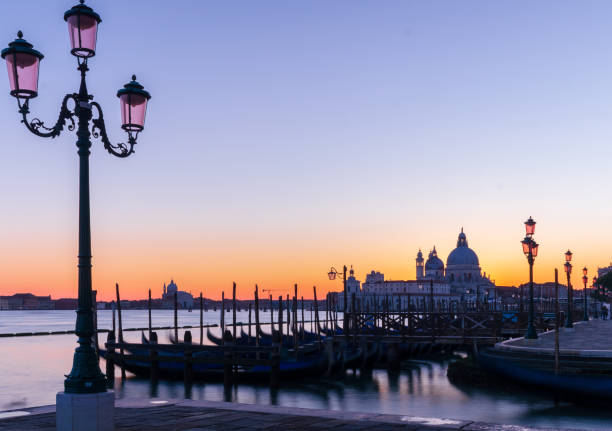 vista en venecia y góndolas con puesta de sol púrpura - venice italy ancient architecture creativity fotografías e imágenes de stock