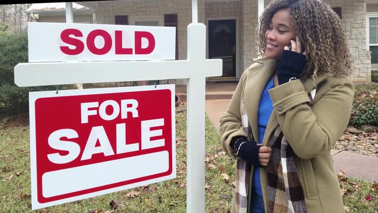 Real Estate Agent.  Home for sale with real estate sign.  Front yard.