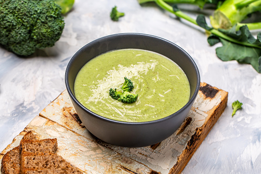 Green vegetable cream soup, with broccoli and parmesan, Clean eating, dieting, vegan, vegetarian, healthy food concept, top view.