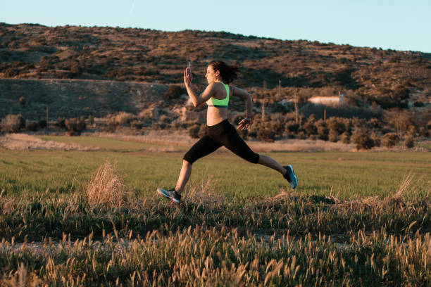 istock Woman runner running through the spring meadow. Workout in a nature. 1305512876