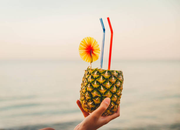 istock Woman's hand holding pineapple cocktail 1305513758