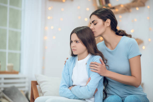 istock Offended looking away girl and hugging caring mother 1305514112