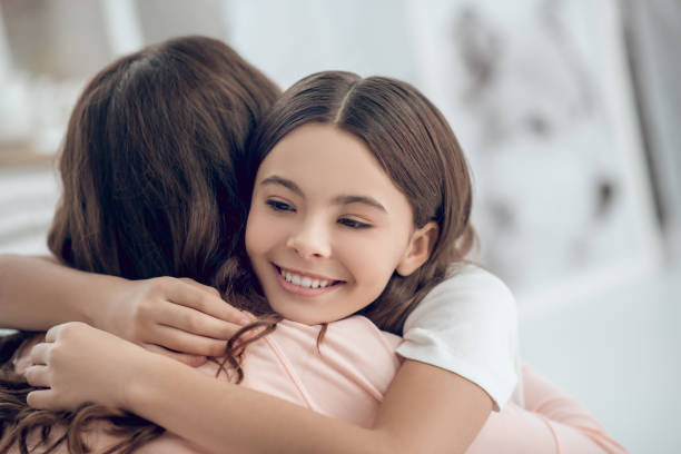 istock Joyful cute girl hugging long haired mom 1305514199