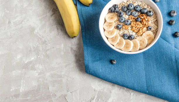 istock Oatmeal with bananas, blueberries and walnut for breakfast 1305516852