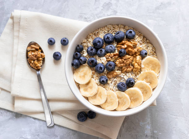 istock Oatmeal with bananas, blueberries and walnut for breakafast 1305516896