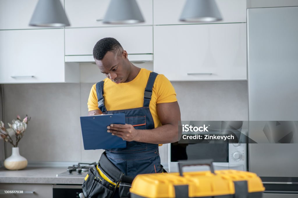 Service Man Images Darkskinned Service Man Standing In The Kitchen And Making Notes Stock ...
