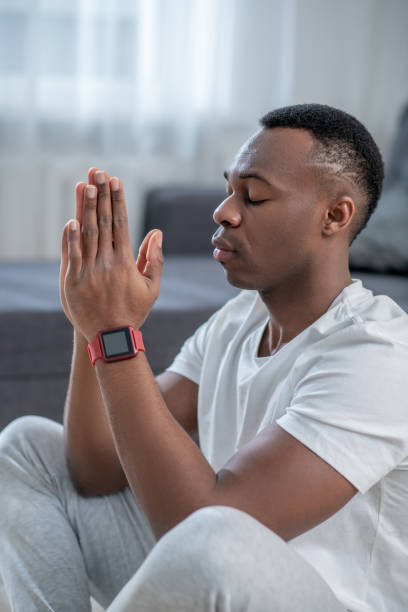 istock Handsome african american guy meditating and looking calm 1305517318