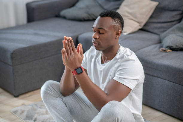 istock Handsome african american guy meditating and looking calm 1305517322