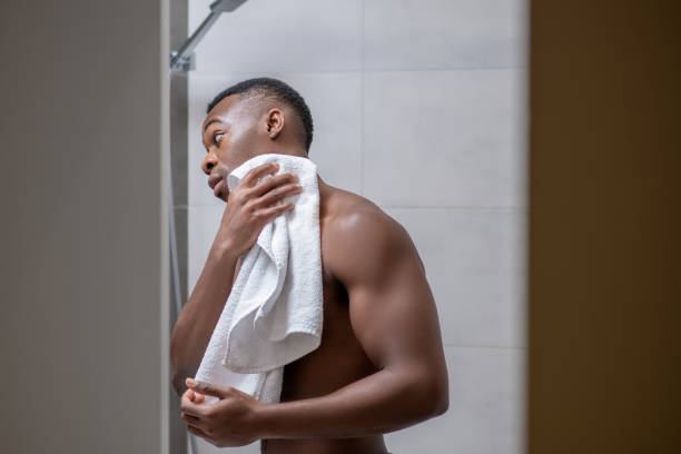 istock Dark-skinned young handsome man in the bathroom with the towel 1305517349