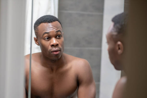 istock African american young handsome man looking at himself in the mirror 1305517366