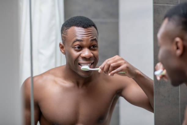 istock African american young handsome man cleaning his teeth 1305517378