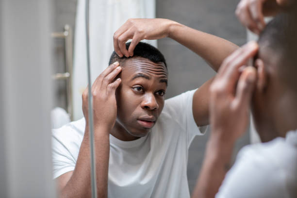 istock African american guy in white tshirt doing his hair 1305517410
