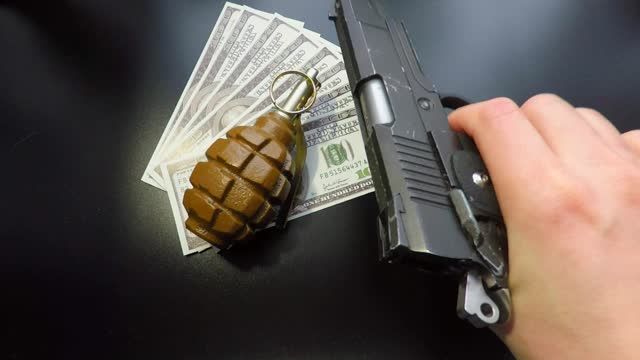 money pistols and hand grenade on black background
